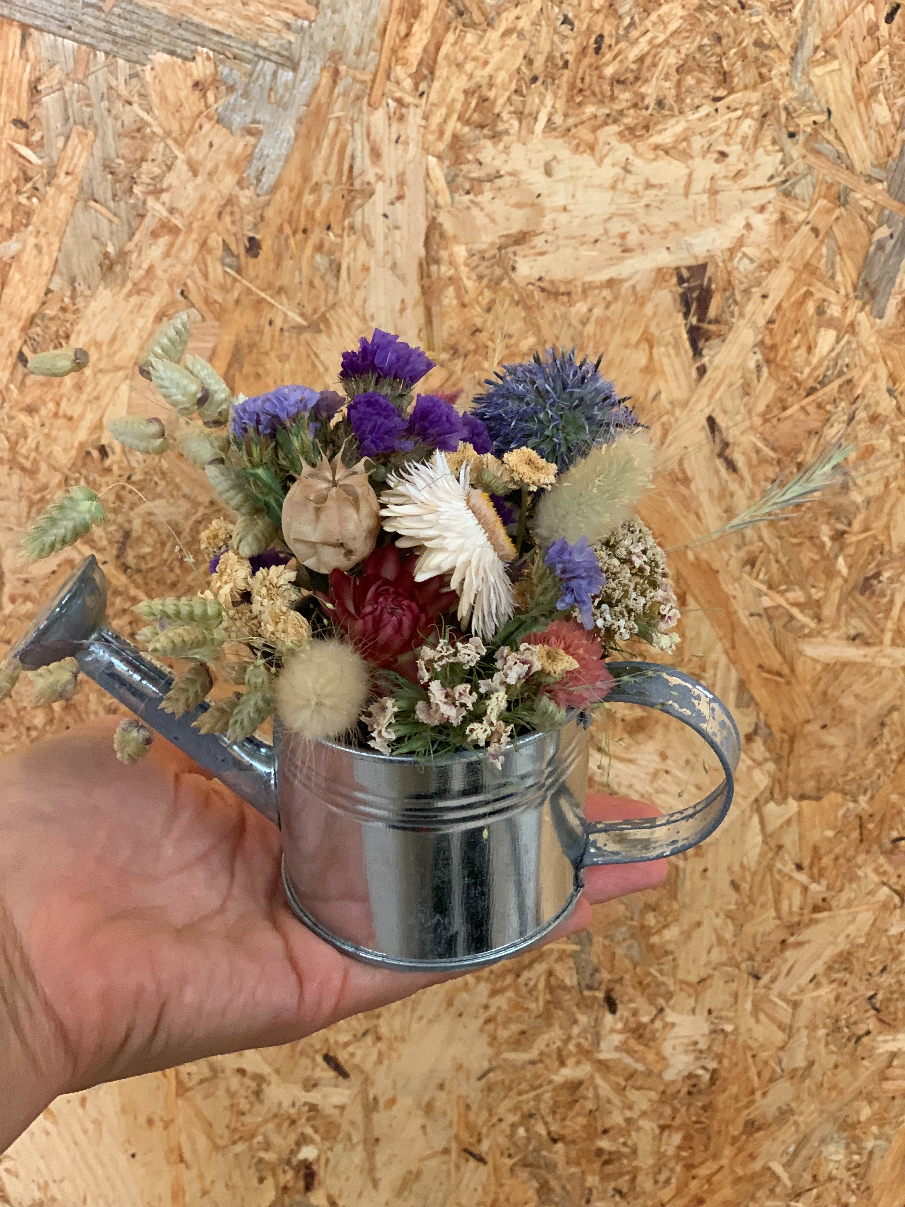 Arrosoir en fer avec fleurs séchées
